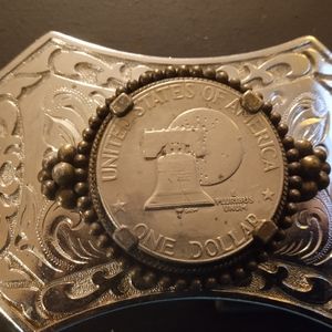 Stainless steel belt buckle with a silver dollar coin in the middle of it